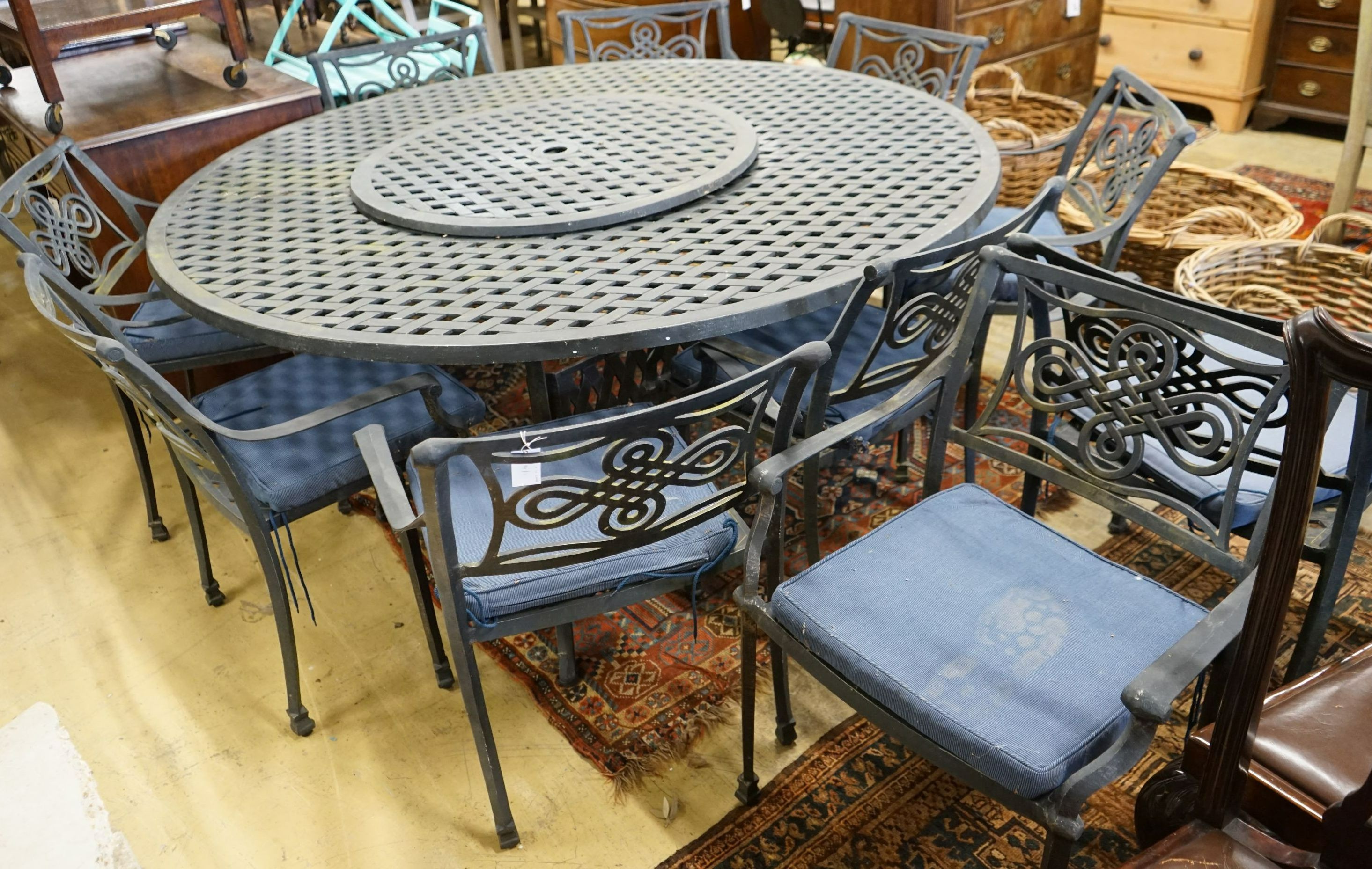 A circular painted aluminium garden table with 'lazy Susan', diameter 180cm, height 73cm together with ten aluminium elbow chairs with seat pads, (one base strut missing from table).